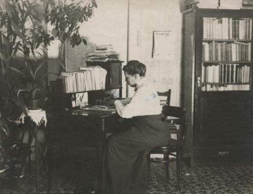 Miina Sillanpää kuvattuna vuonna 1915. Hän istuu kirjoituspöydän ääressä.